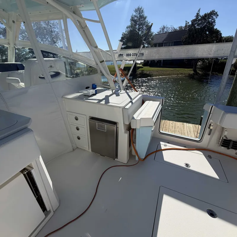 Slide: The Image of The image shows the cockpit of a 2023 Cobia 330 Dual Console overlooking a calm river. - 7