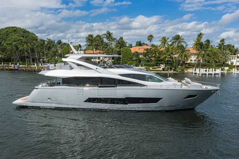 The Image of 2018 Sunseeker 86 Yacht cruising on a scenic waterway with palm trees in the background. - 0