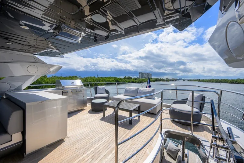 Slide: The Image of Luxurious 2018 Sunseeker 86 Yacht deck with seating, grill, and scenic water view. - 60