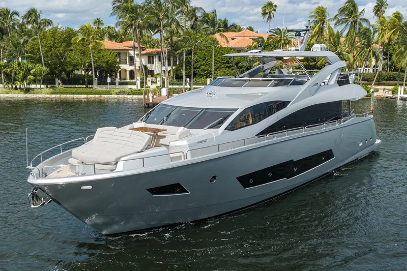 Slide: The Image of 2018 Sunseeker 86 Yacht cruising near palm-lined waterfront homes. - 1