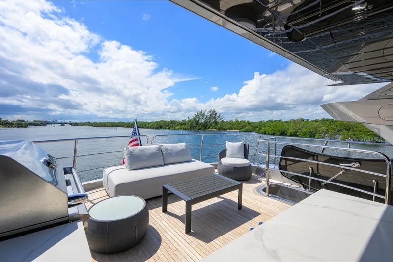 Slide: The Image of Luxurious 2018 Sunseeker 86 Yacht deck with seating, grill, and scenic water view. - 61