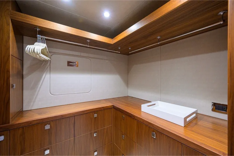 Slide: The Image of Luxurious wooden closet interior on 2018 Sunseeker 86 Yacht, featuring hangers and a white tray. - 35
