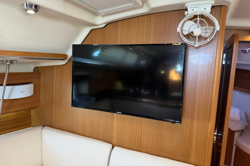 Slide: The Image of Interior of 2014 Catalina 445 yacht with mounted TV and fan on wooden paneling. - 46