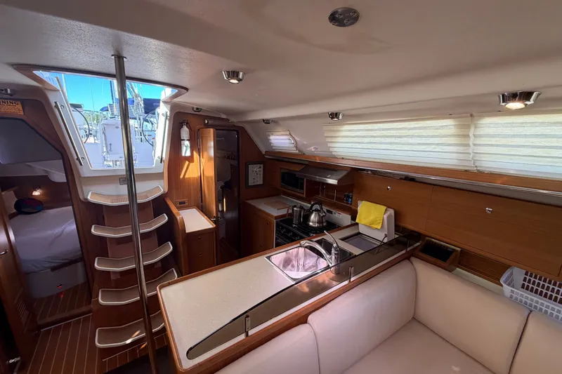 Slide: The Image of Interior of a 2014 Catalina 445 sailboat featuring a modern kitchen and cozy seating area. - 37
