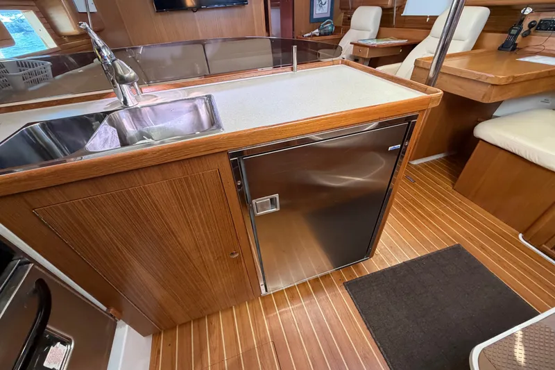 Slide: The Image of Interior of 2014 Catalina 445 yacht featuring a modern kitchen with wood finish. - 35