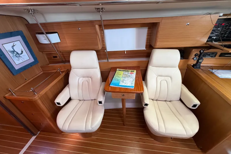 Slide: The Image of Interior of 2014 Catalina 445 yacht with two cream leather chairs and a wooden table. - 42