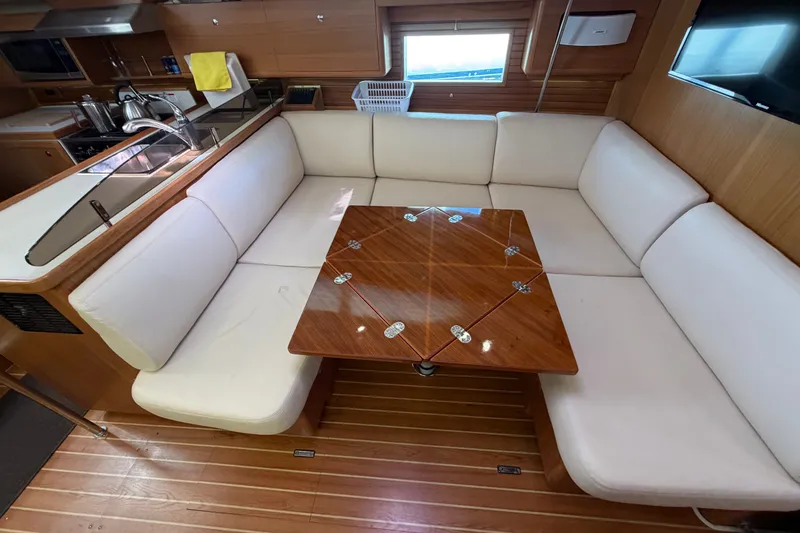 Slide: The Image of Interior of 2014 Catalina 445 yacht with white seating and wooden table. - 45
