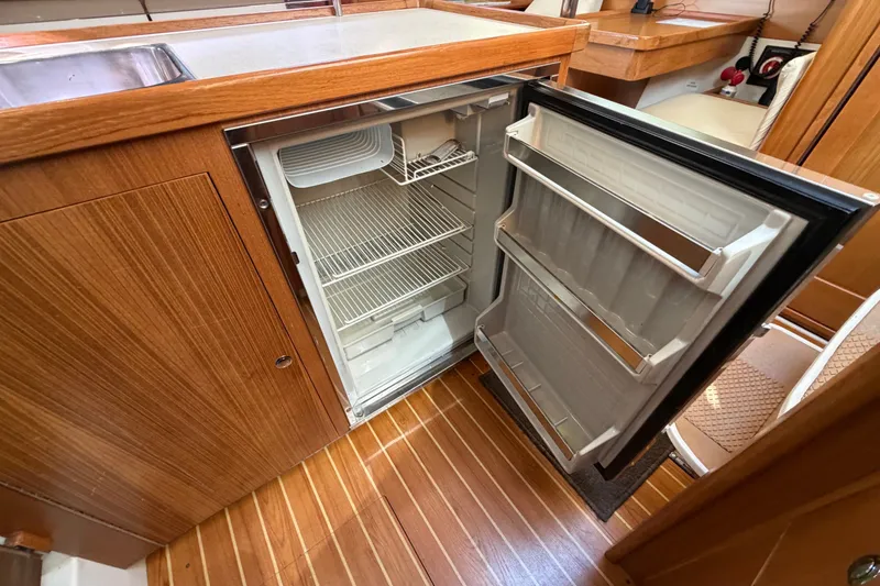 Slide: The Image of Open refrigerator in 2014 Catalina 445 yacht kitchen with wooden cabinetry and flooring. - 36