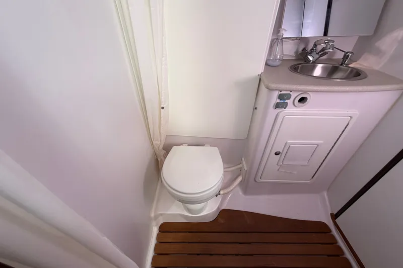 Slide: The Image of Compact bathroom in a 2014 Catalina 445 yacht with toilet, sink, and wooden floor mat. - 48