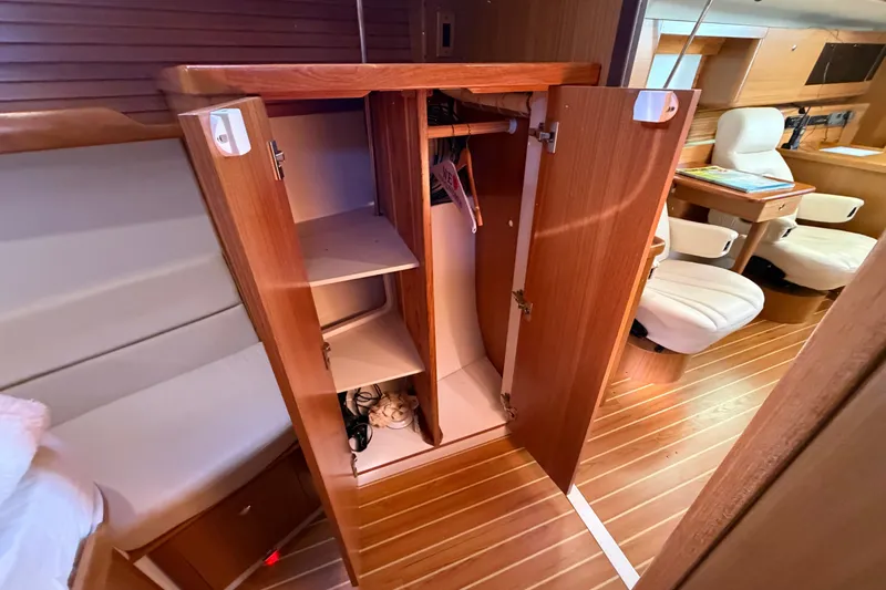 Slide: The Image of Interior of 2014 Catalina 445 sailboat showing open wooden cabinet and seating area. - 57