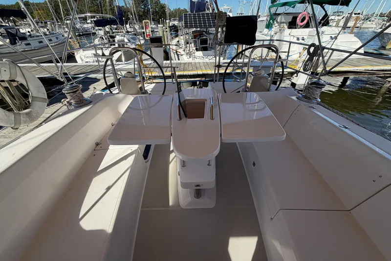 Slide: The Image of Cockpit of a 2014 Catalina 445 sailboat, featuring dual steering wheels and a central table. - 16
