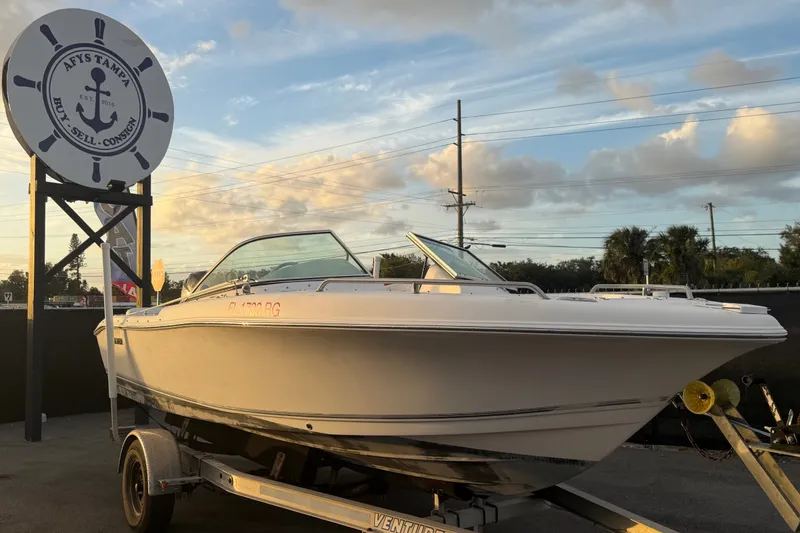 The Image of 2011 Tidewater 196 DC Explorer boat on trailer at dealership, under a clear sky. - 0