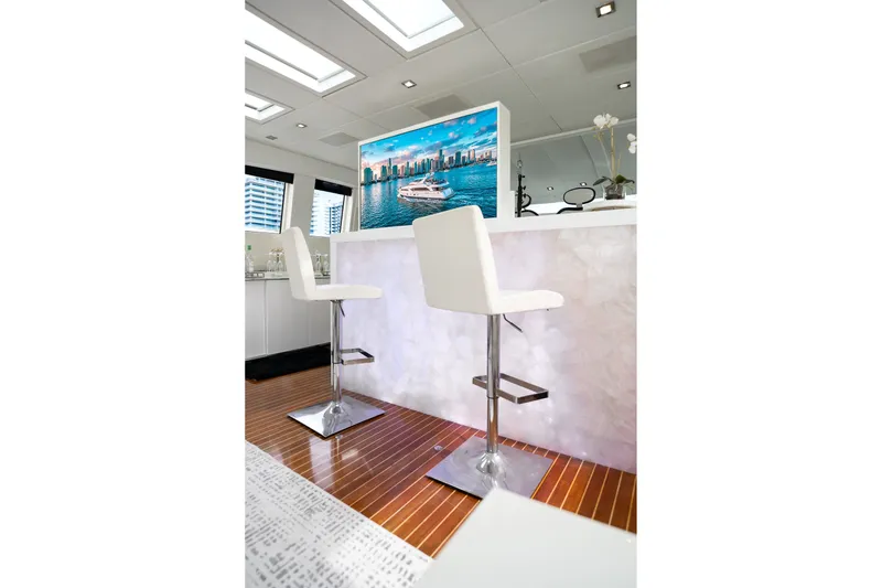 Slide: The Image of Luxurious yacht interior with modern bar stools, sleek design, and a scenic view on screen. Arno Leopard 31, 2006. - 9