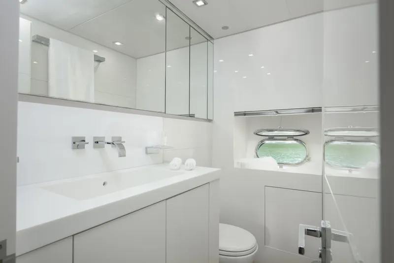 Slide: The Image of Luxurious yacht bathroom with modern fixtures, white decor, and ocean view portholes. Arno Leopard 31, 2006. - 21