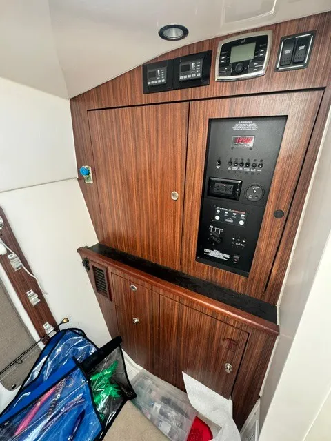 Slide: The Image of Interior view of a 2016 Pursuit DC 325 Dual Console with wood paneling and control instruments. - 25