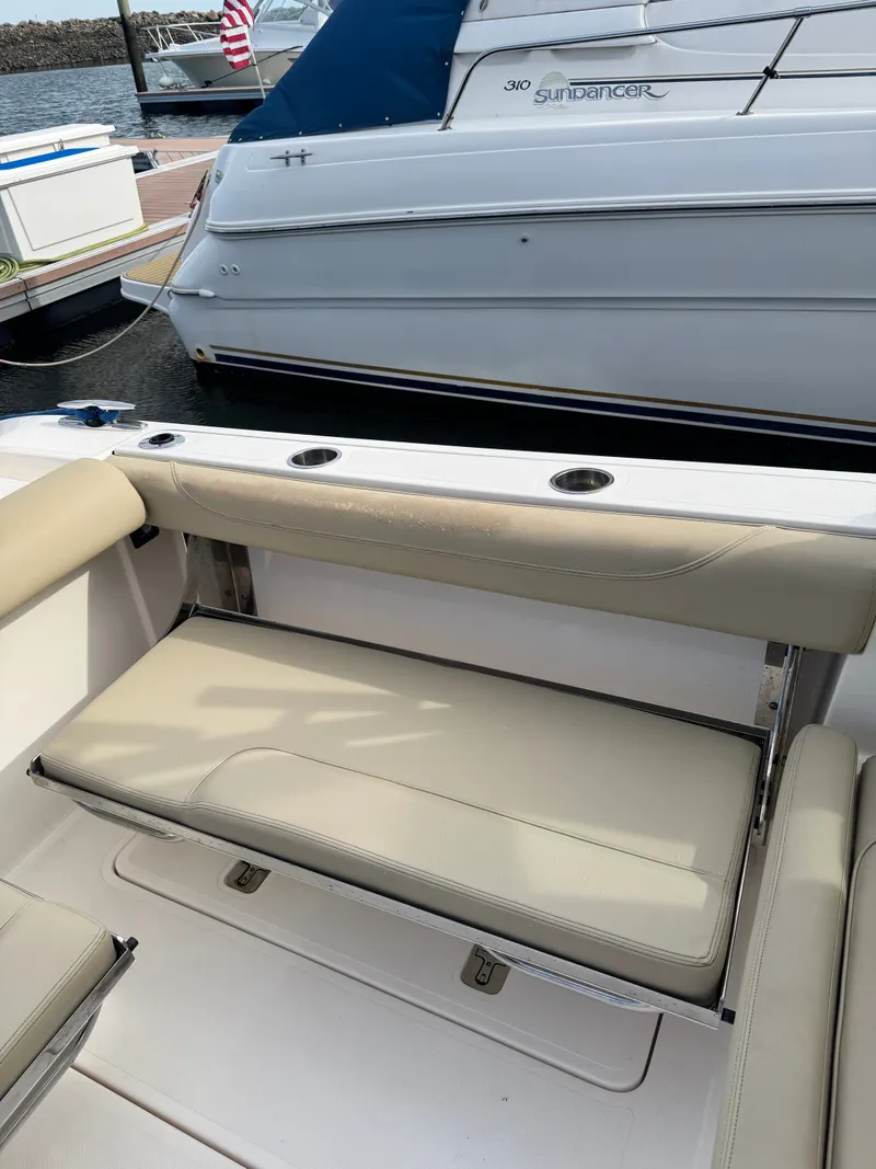 Slide: The Image of A seating area on a 2016 Pursuit DC 325 Dual Console boat, featuring beige upholstery. - 19