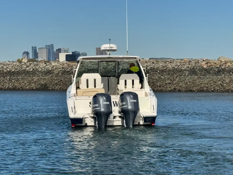 Slide: The Image of A 2016 Pursuit DC 325 Dual Console boat with twin outboard engines on the water. - 10
