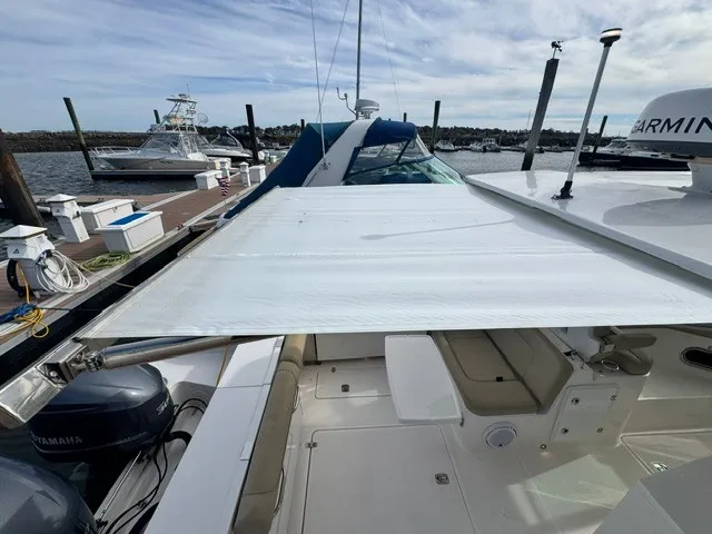 Slide: The Image of A 2016 Pursuit DC 325 Dual Console boat docked, featuring a retractable sunshade. - 28