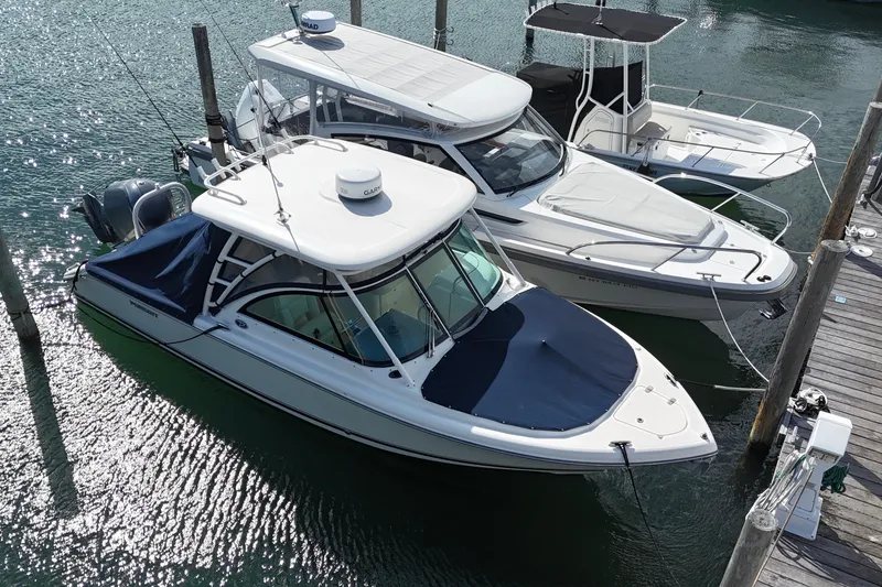Slide: The Image of 2011 Pursuit DC 265 Dual Console boat docked in marina, aerial view. - 4