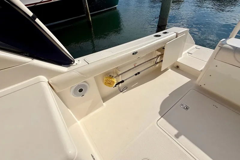 Slide: The Image of 2011 Pursuit DC 265 Dual Console boat interior with storage compartment and cleaning tools. - 18