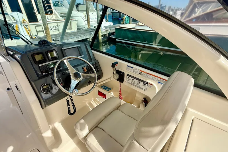 Slide: The Image of 2011 Pursuit DC 265 Dual Console boat interior with steering wheel and control panel. - 6