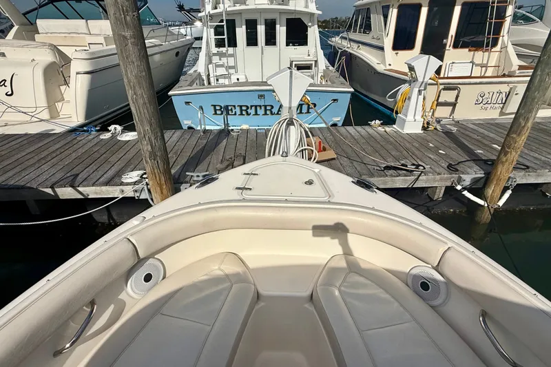 Slide: The Image of 2011 Pursuit DC 265 Dual Console boat docked at marina with other vessels. - 15