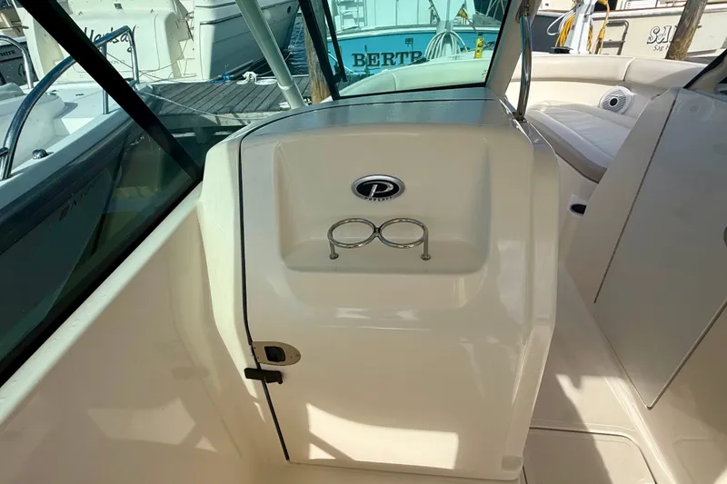 Slide: The Image of 2011 Pursuit DC 265 Dual Console boat interior with cup holders and seating area. - 11