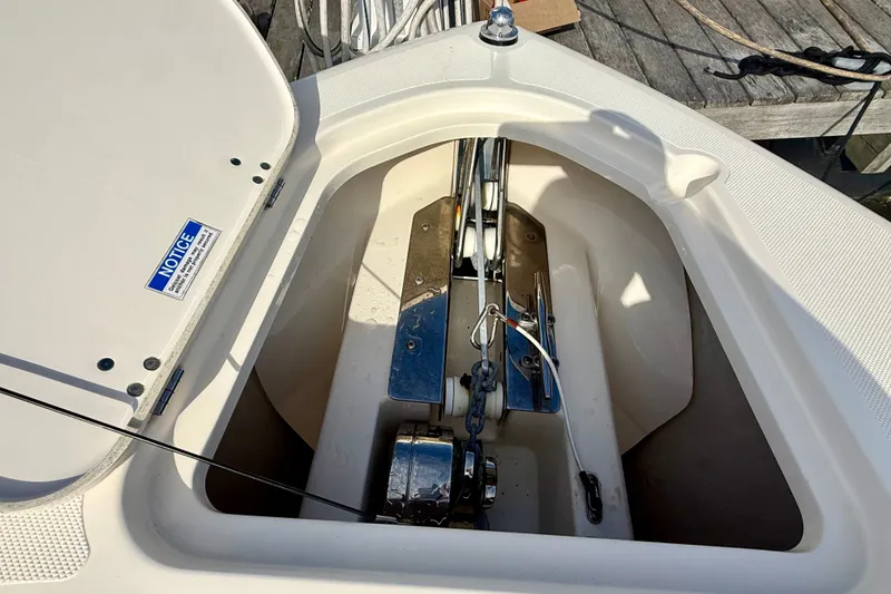 Slide: The Image of Anchor compartment of 2011 Pursuit DC 265 Dual Console boat, showing chain and winch. - 16