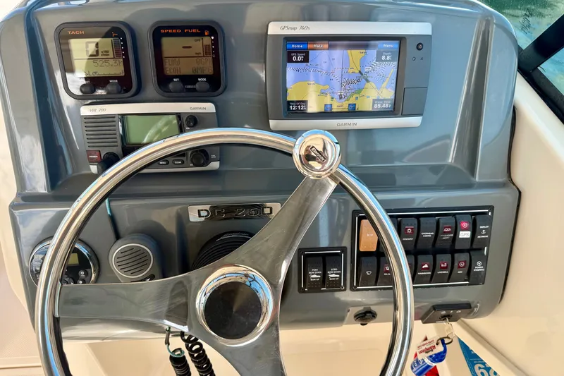 Slide: The Image of Steering console of 2011 Pursuit DC 265 Dual Console with navigation and control instruments. - 10