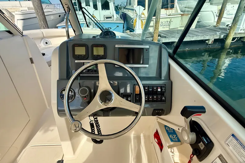 Slide: The Image of 2011 Pursuit DC 265 Dual Console boat dashboard with steering wheel and controls. - 9
