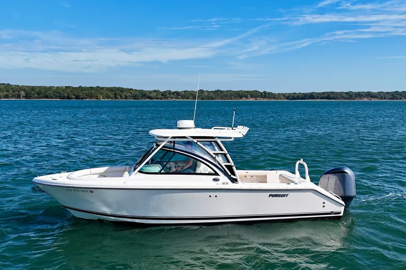 Slide: The Image of 2011 Pursuit DC 265 Dual Console boat on calm blue water under clear sky. - 3