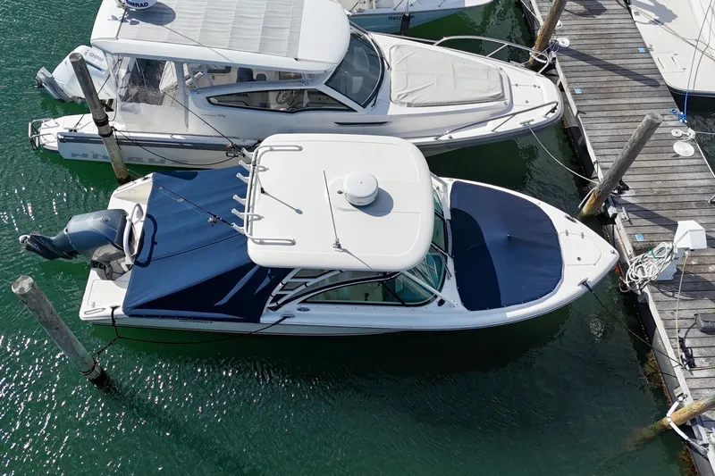 Slide: The Image of Overhead view of a 2011 Pursuit DC 265 Dual Console boat docked in clear water. - 5