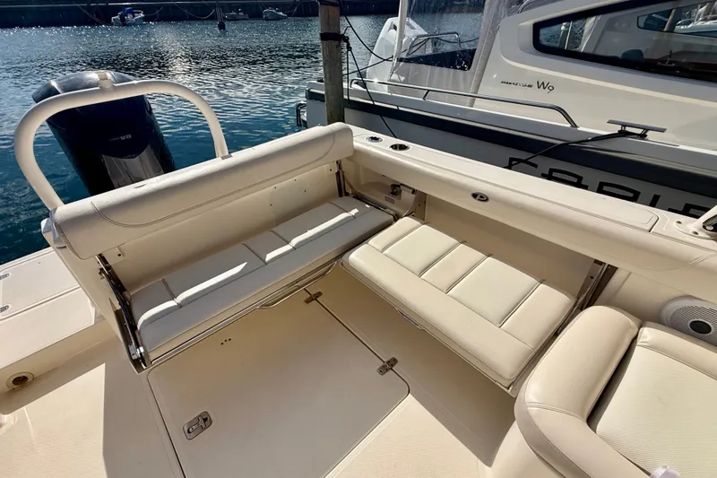 Slide: The Image of 2011 Pursuit DC 265 Dual Console boat with beige seating and outboard motor. - 21