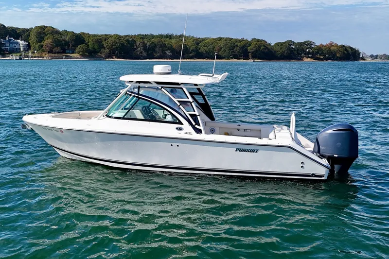 Slide: The Image of 2011 Pursuit DC 265 Dual Console boat on calm water, scenic background. - 1