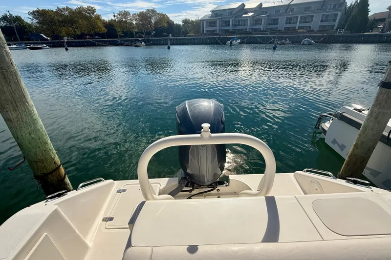 Slide: The Image of 2011 Pursuit DC 265 Dual Console boat docked in a serene marina setting. - 26