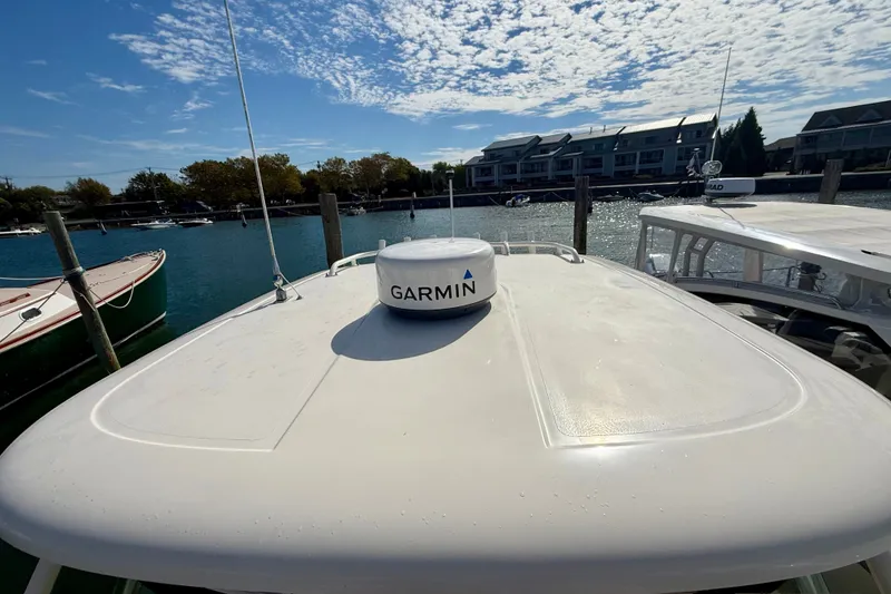 Slide: The Image of 2011 Pursuit DC 265 Dual Console boat with Garmin radar, docked by waterfront homes. - 31
