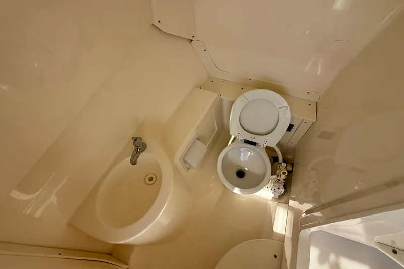 Slide: The Image of 2011 Pursuit DC 265 Dual Console boat bathroom with toilet and sink. - 29
