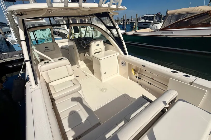 Slide: The Image of 2011 Pursuit DC 265 Dual Console boat interior at marina, showcasing seating and helm. - 23