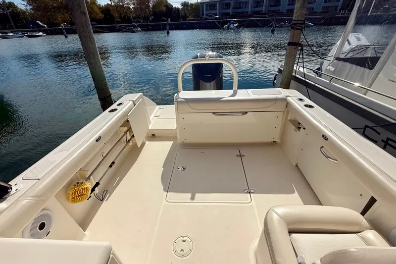 Slide: The Image of 2011 Pursuit DC 265 Dual Console boat interior at a marina dock. - 17