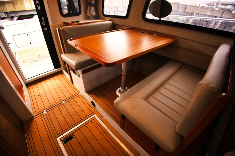Slide: The Image of Interior of the KingFisher 3425 GFX Offshore with a wooden table and cushioned seating. - 21