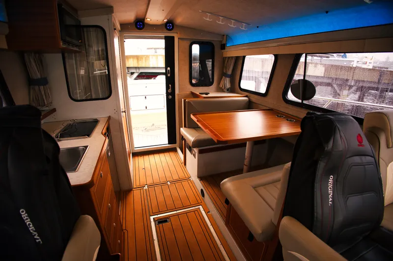 Slide: The Image of Interior of the KingFisher 3425 GFX Offshore with wood flooring, table, and seating. - 20
