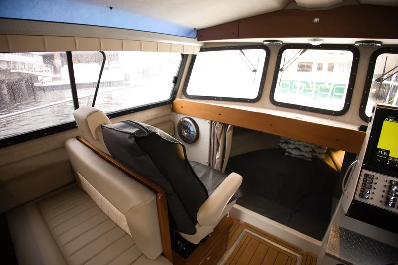 Slide: The Image of Interior of a 2022 KingFisher 3425 GFX Offshore with comfortable seating and large windows. - 19