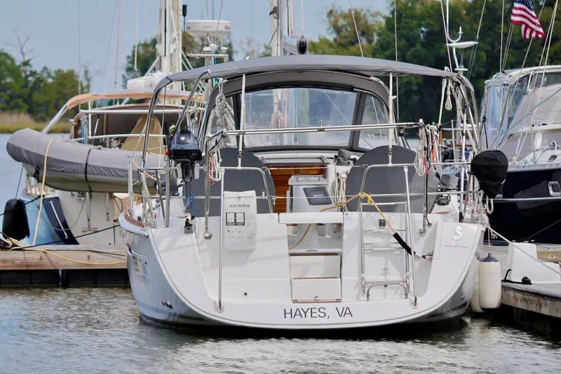 Slide: The Image of A 2011 Beneteau 40 docked in a marina. It features a gray canopy and is registered in Hayes, VA. - 30