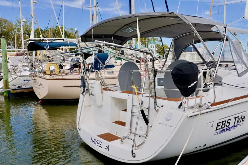 Slide: The Image of A 2011 Beneteau 40 docked at a marina. It features a gray sunshade and is registered in Hayes, VA. - 28