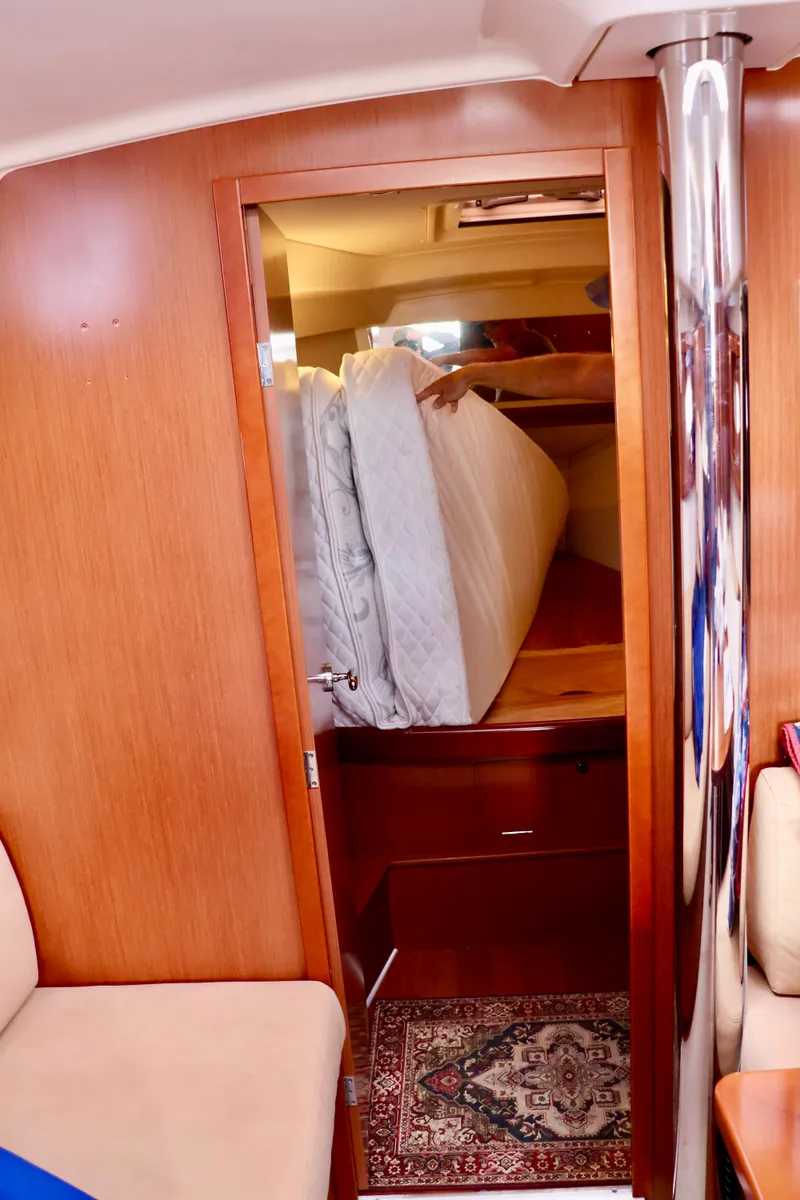 Slide: The Image of Interior of a 2011 Beneteau 40 with wooden walls and a stacked mattress. - 17