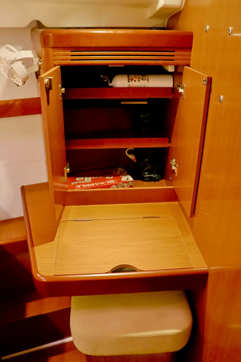 Slide: The Image of An open wooden cabinet with shelves and a fire extinguisher inside. - 15