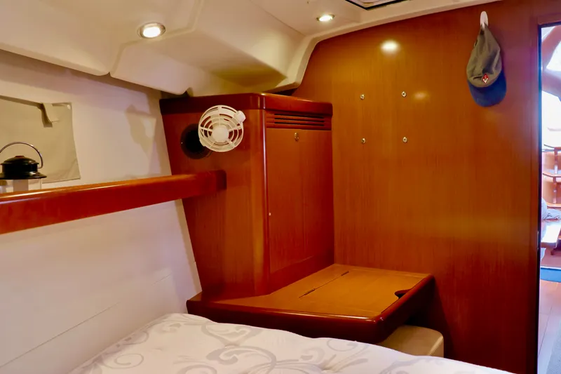Slide: The Image of Interior of a 2011 Beneteau 40 featuring wooden furnishings and a bed. - 12
