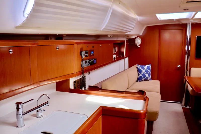 Slide: The Image of Interior of a 2011 Beneteau 40 with wooden cabinetry and a beige sofa. - 6