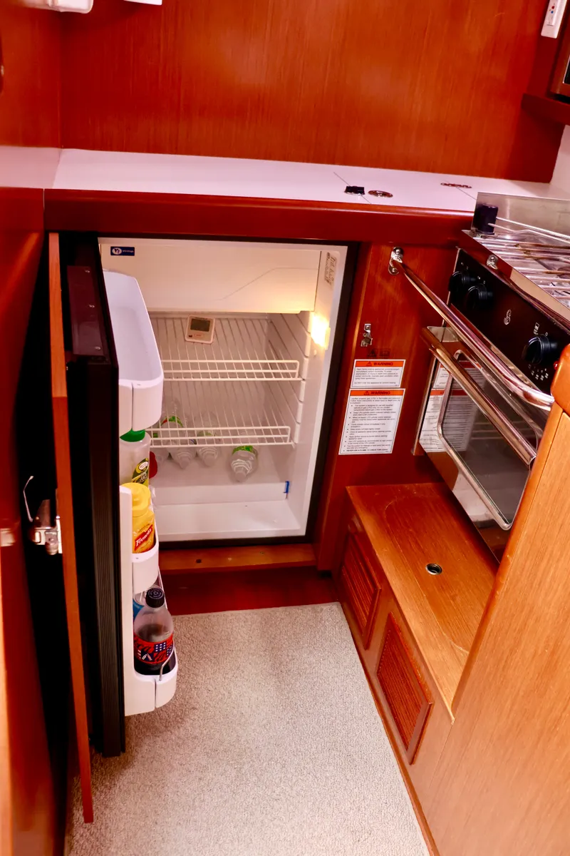 Slide: The Image of Interior view of a 2011 Beneteau 40 galley with an open refrigerator. - 8
