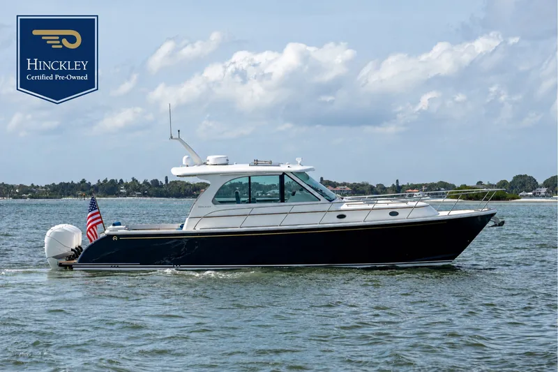 The Image of 2023 Hinckley Sport Boat 40 X on calm water with an American flag. - 0
